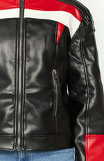 Close-up of the black faux leather biker jacket with silver main zipper, vertical zippered pocket, and red and white shoulder panels