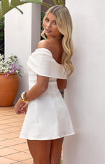Side view of a white off-shoulder mini dress with a wide folded neckline and A-line skirt