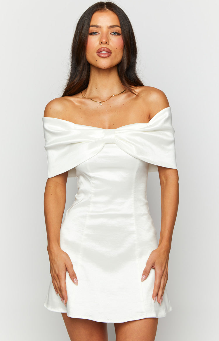 Close-up of the off-shoulder neckline and large bow detail on a white mini dress