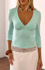 Turquoise jersey top with a deep V-neckline and fitted bust seam detail