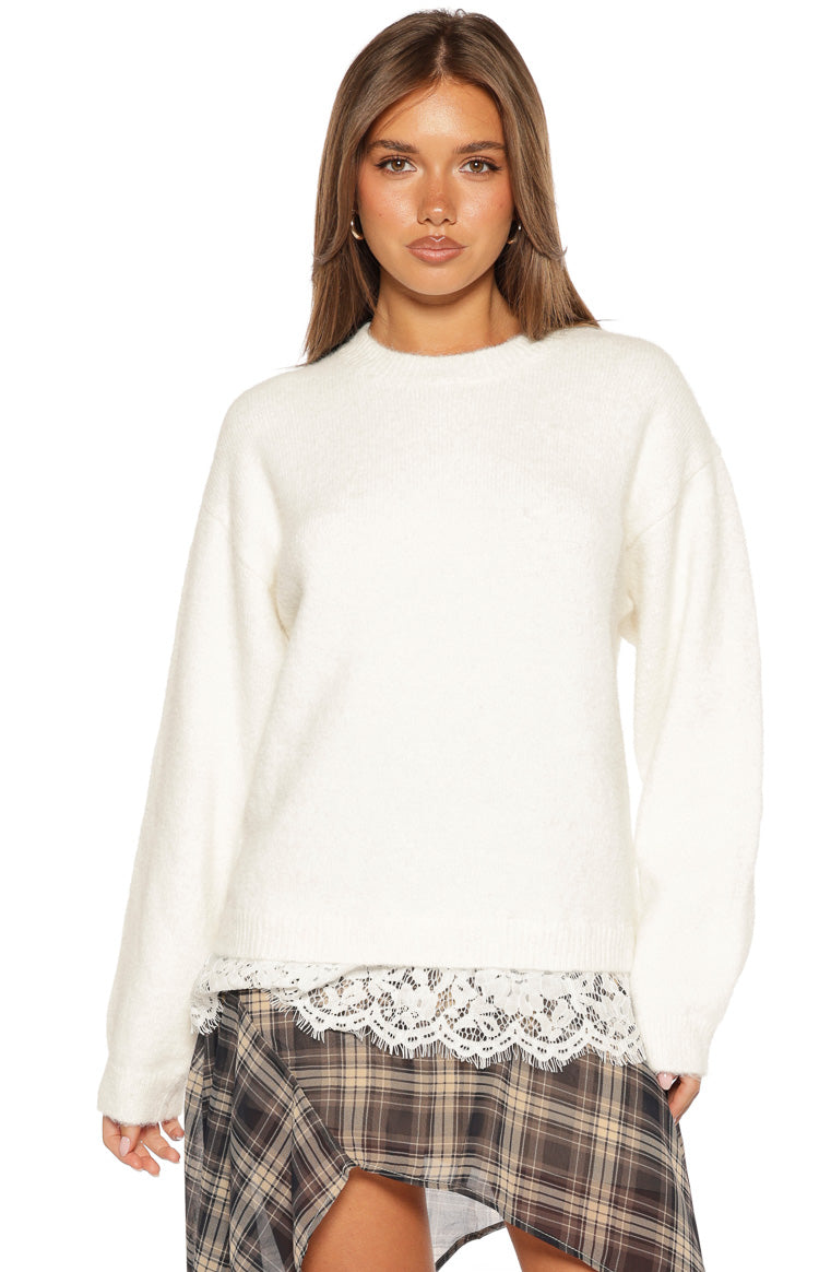 Cream knit sweater with a crew neck and long sleeves, showing the delicate lace trim at the hem