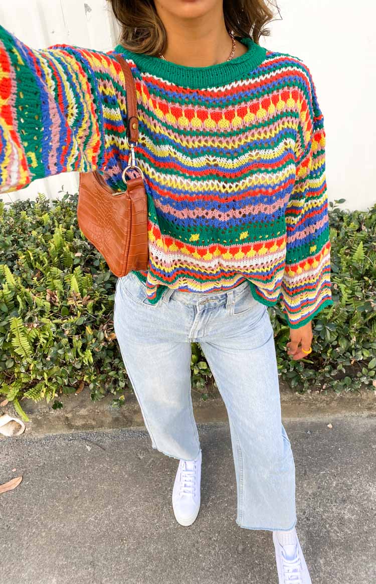 Multi-coloured open knit sweater with horizontal stripes, wavy patterns, long sleeves, and a scalloped hem