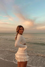 Side view of white knit ruffle shorts with tiered ruffles and a textured knit pattern