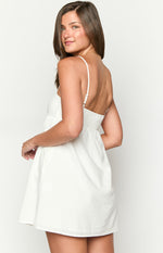 Back view of a white mini dress with thin adjustable straps and a shirred elasticated back