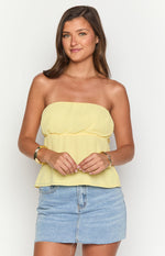 Yellow strapless top with a gathered elasticated bust and a flowy peplum hem