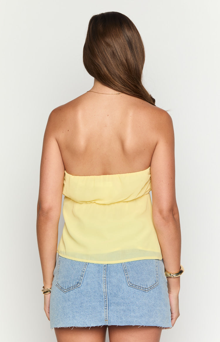 Back view of the yellow strapless top with a gathered elasticated band and flowy hem