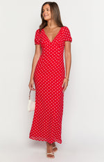 Red maxi dress with white polka dots, a deep V-neck, short puff sleeves, and a flowing silhouette