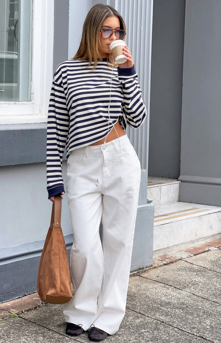 Full length view of white denim slouchy jeans with a relaxed wide leg and drawstring waist