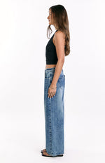 Side view of mid wash denim slouchy jeans with a wide leg and heart pocket detail on the hip