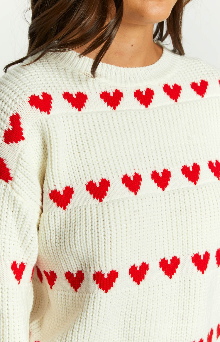 Close-up of the white chunky knit jumper with red heart pattern and ribbed texture