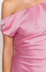 Detail shot of the pink satin mini dress with a draped one-shoulder neckline and ruched side