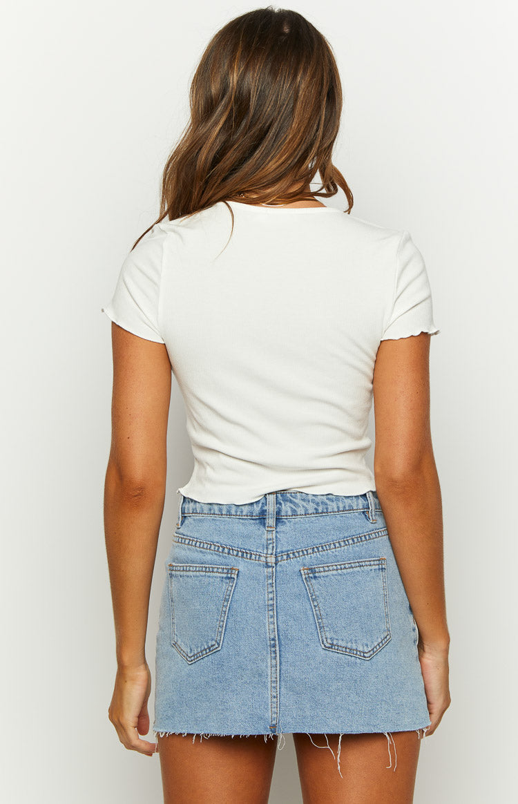 Rear view of a white ribbed short sleeve top with scalloped edges on the sleeves and hem