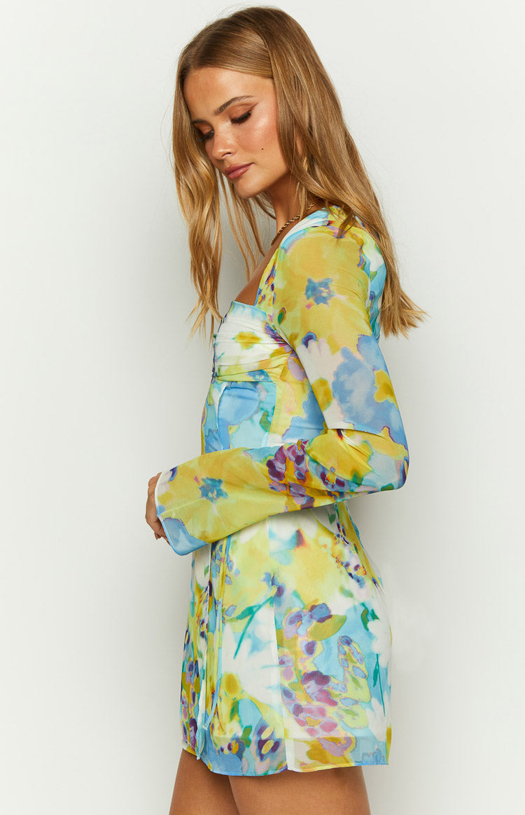 Side view of the blue, yellow, and purple floral mini dress showing the long sheer sleeves and ruched bust