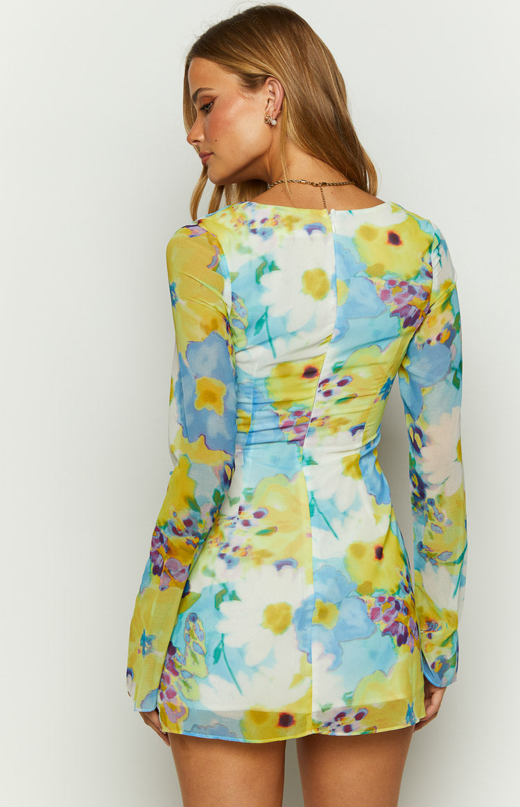 Close-up of the ruched bust, side seam, and waist tie detail with white rings on a blue and yellow floral dress