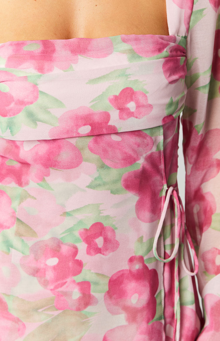 Rear view of the pink floral print mini dress showing the sheer long sleeves and fitted waist
