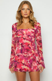 Front view of a pink floral print mini dress with a square neckline, long sleeves, and a tie waist detail
