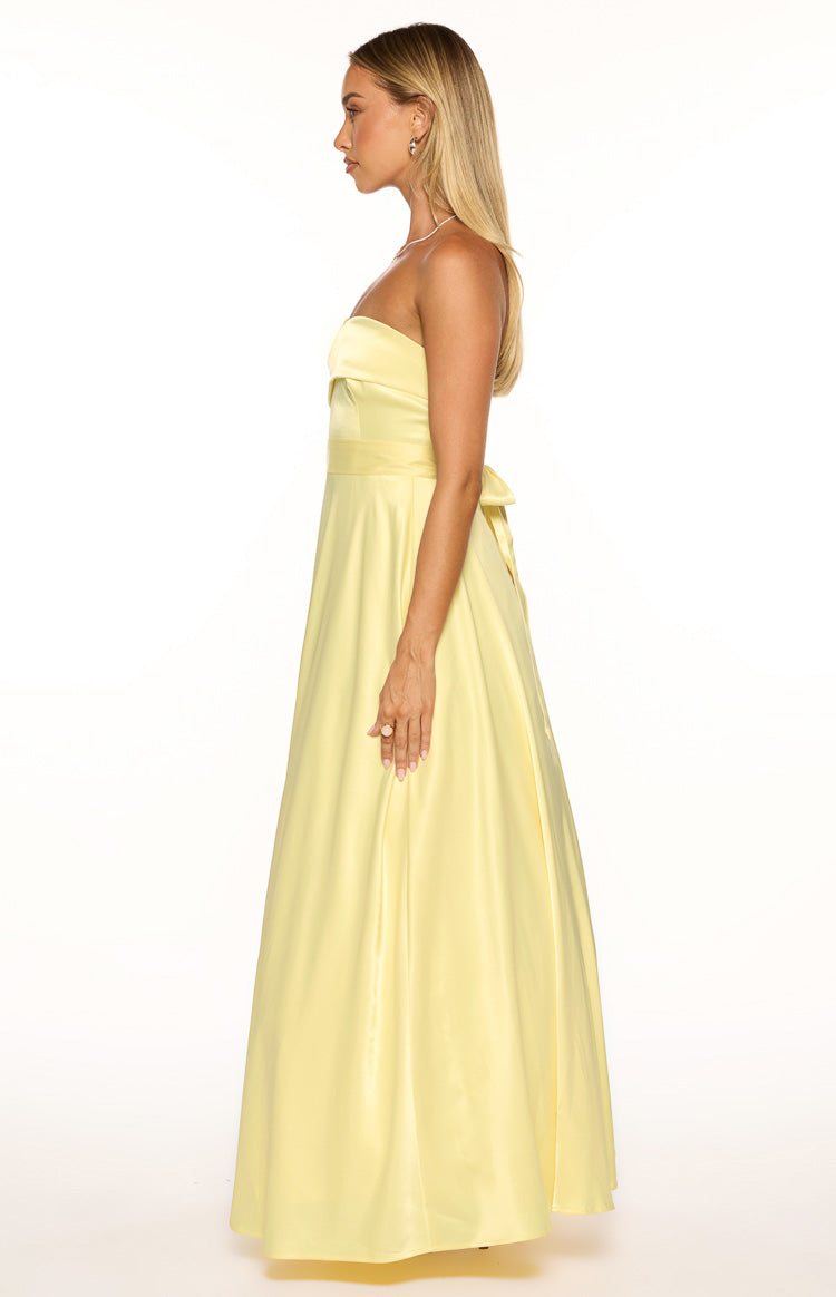 Front view of a yellow satin strapless maxi dress with a ruched bodice, a wide waistband, and a high leg slit