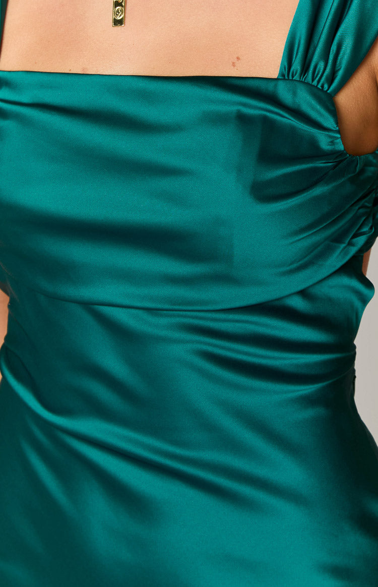 Back view of the emerald mini dress showing the open back with criss-cross tie straps and ruched cap sleeves