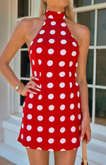 Front view of the red polka dot mini dress with a high halter neckline