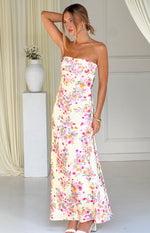 Side view of a yellow floral strapless maxi dress with pink and purple blooms and a flowy skirt