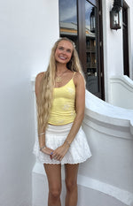 Yellow spaghetti strap top with white beaded floral embroidery across the front
