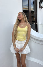 Fitted yellow cami top with thin spaghetti straps and white beaded floral appliques