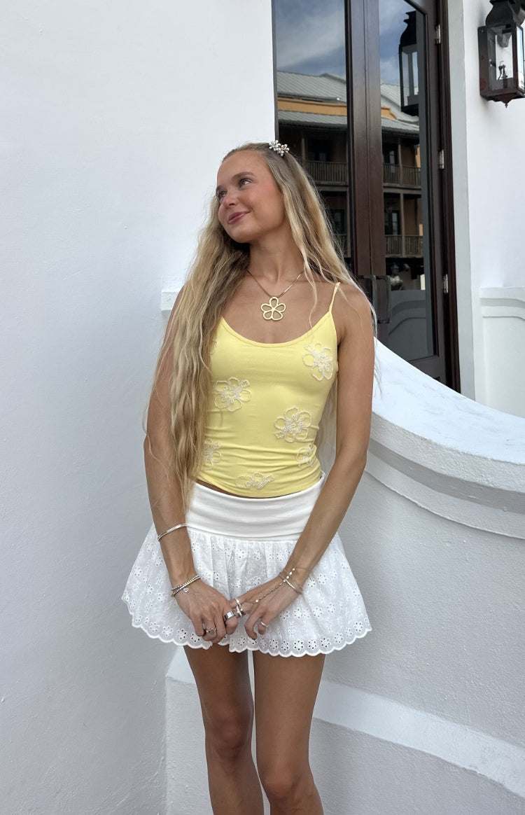 Fitted yellow cami top with thin spaghetti straps and white beaded floral appliques