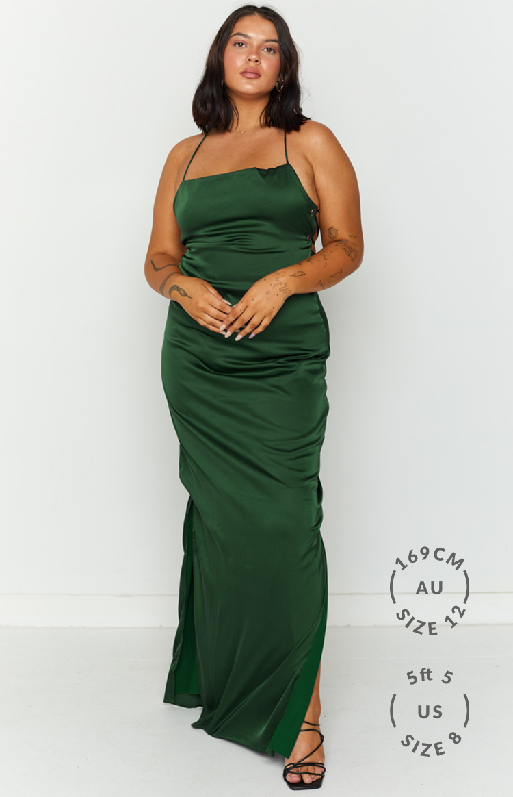Emerald green satin maxi dress with thin spaghetti straps, side lace-up detail, and a high leg split