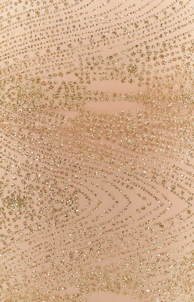 Detail shot of the gold glitter wavy geometric pattern on the nude mesh of a formal dress