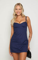 blonde model wearing navy mini dress with bust detail and flower straps