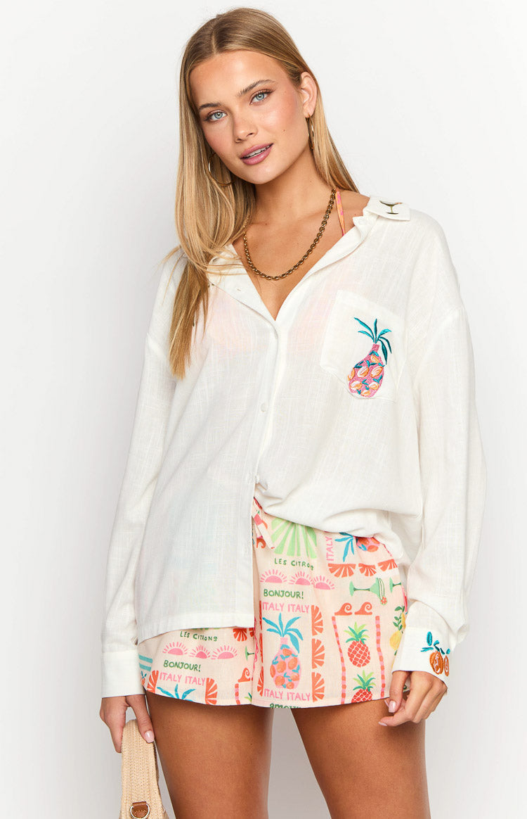 White long sleeve shirt with an embroidered pineapple on the chest pocket and citrus design on the right cuff