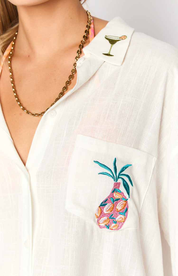 Close-up of the white long sleeve shirt with a green martini glass embroidered collar and pineapple embroidered pocket