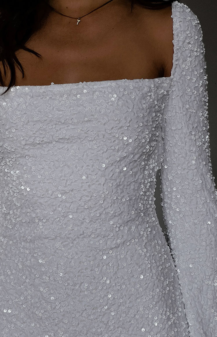 Close-up of the white sequin velvet mini dress showing the square neckline and long sleeve texture
