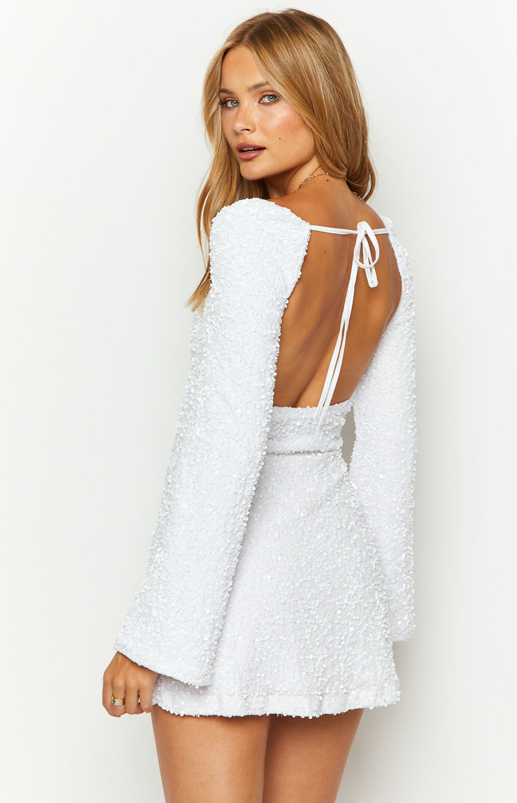 Rear view of a white velvet sequin long sleeve mini dress with a deep open back and tie closure