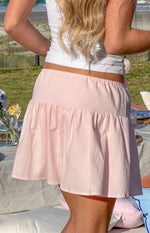 Rear view of a pink mini skirt with an elasticated waist and gathered tiered hem