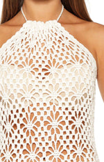 Close-up of the white crochet halter neckline and intricate floral open-knit pattern of the mini dress