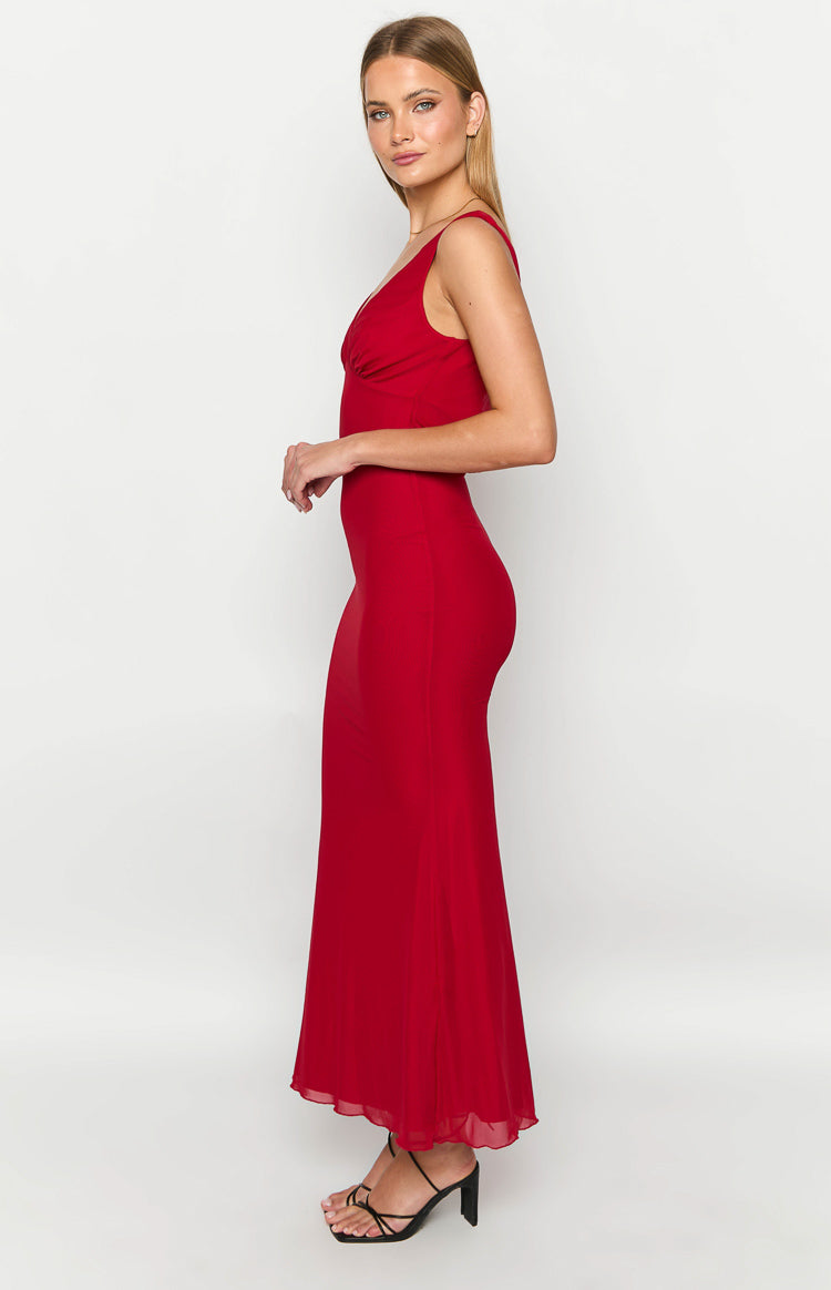 Side view of a red maxi dress with a ruched V-neckline, fitted bodice, and flowy skirt with a sheer hem