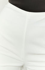 Close-up of the white pants fabric with a subtle textured finish and a vertical seam