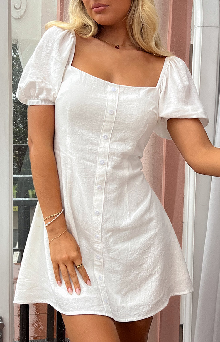 White textured mini dress with square neckline, puffed cap sleeves, and full button-front