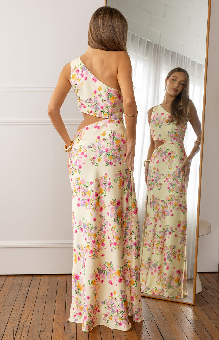Rear view of the yellow floral satin maxi dress showing the one-shoulder neckline and side cutouts