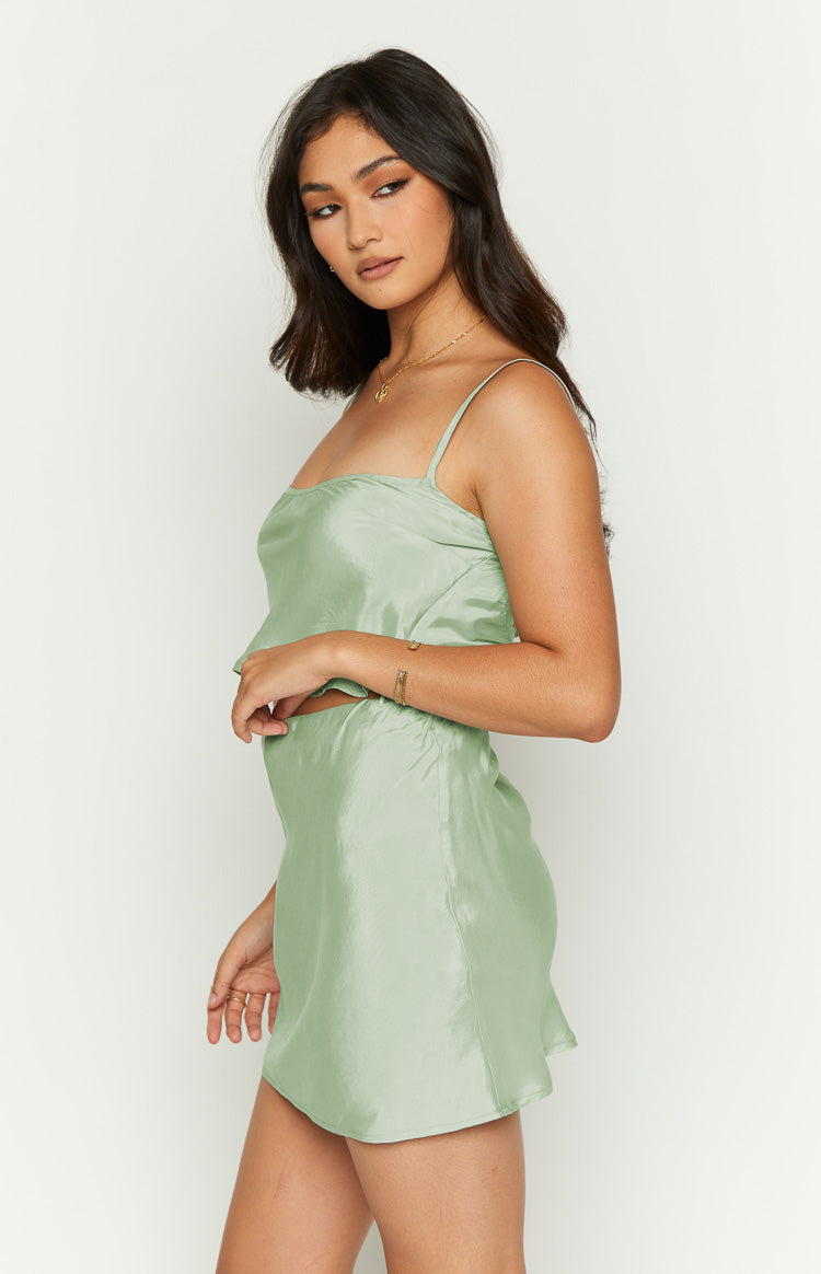 Side view of a sage satin top with a square neckline, thin spaghetti straps, and a relaxed, flowy fit