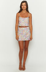 Front view of a fitted mini skirt with a painted floral pattern in shades of pink, yellow, and blue