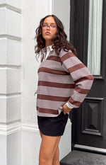 Side view of a brown and white striped long sleeve polo with a white collar and relaxed fit