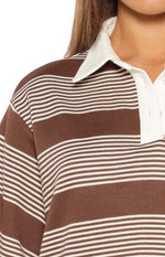 Close-up of the brown and white striped knit fabric, showing the white polo collar and button placket