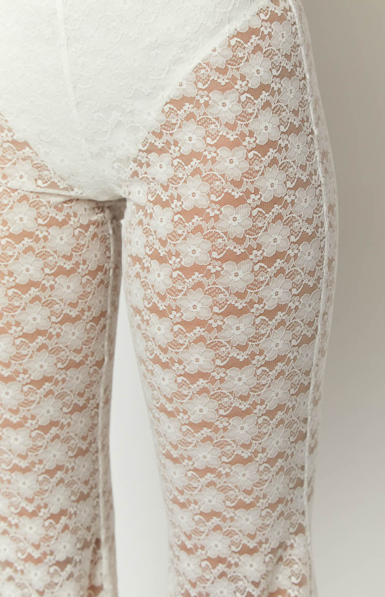 Close-up of the sheer white floral lace pattern on the fitted pants