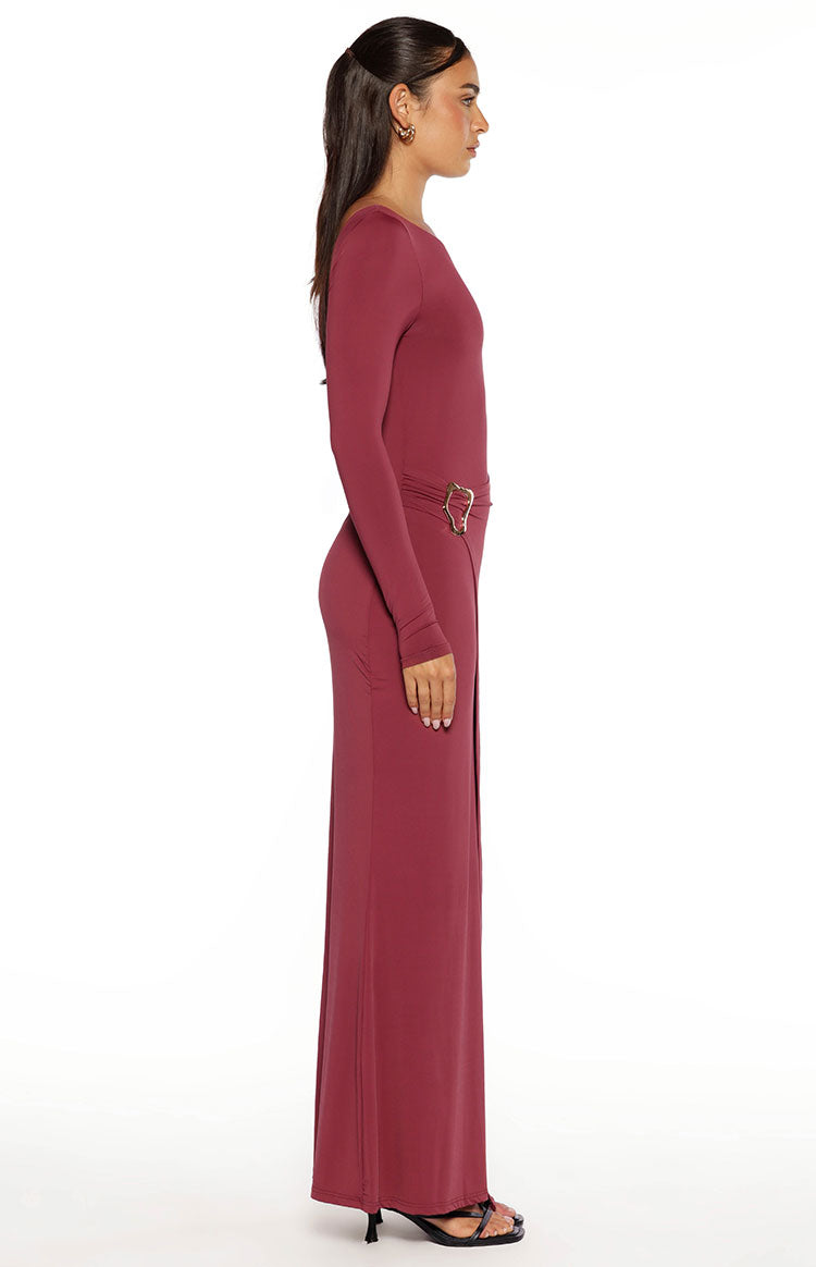 Side view of a burgundy long sleeve wrap maxi dress with a gold heart buckle detail at the waist