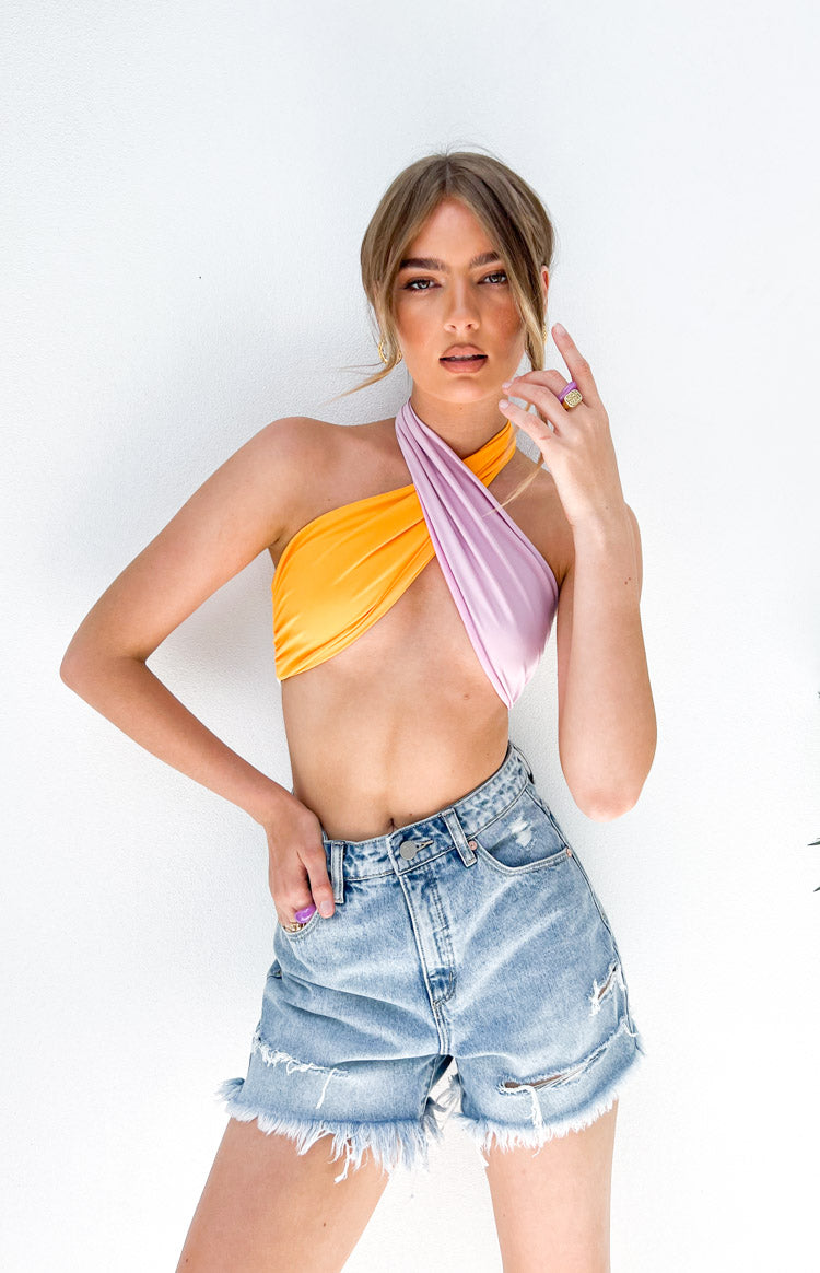 Side view of the orange and white halter top with a ruched front and long pink and orange ties