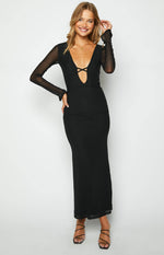 Black maxi dress with a deep V-neckline, criss-cross bust detail, and sheer mesh long sleeves with ruched cuffs