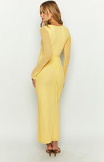 Rear view of the yellow maxi dress with sheer long sleeves and a tie-back waist