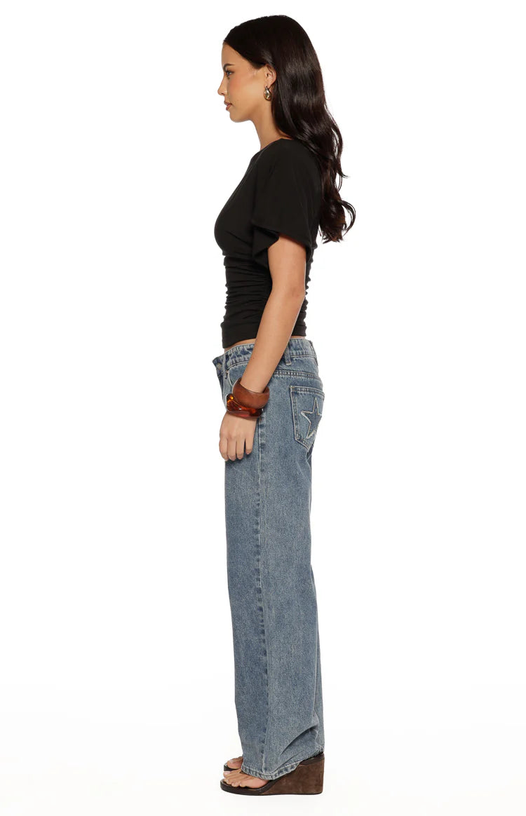 Side view of a black jersey top with a ruched waist and short sleeves